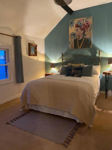 a bedroom with a bed and a painting on the wall at Mingo Cottage in Bewdley
