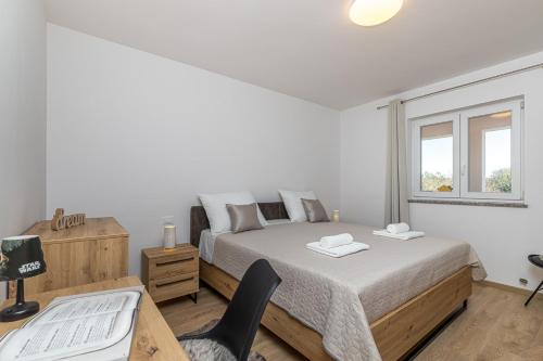 a bedroom with a bed and a desk and a chair at Holiday House Sunset in Bale