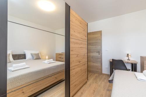 a bedroom with a sliding glass door with a bed and a desk at Holiday House Sunset in Bale