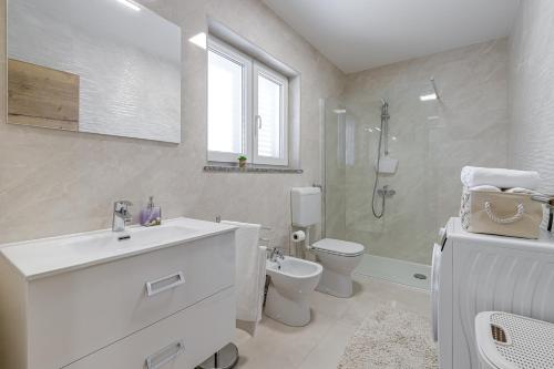 a bathroom with a sink and a toilet and a shower at Holiday House Sunset in Bale