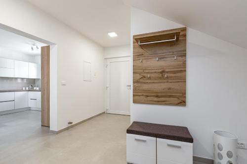 a kitchen with white cabinets and a wooden wall at Holiday House Sunset in Bale