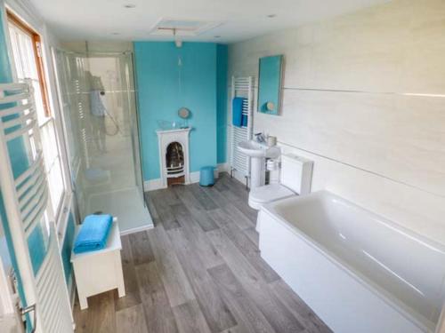 bagno con vasca, doccia e lavandino di 1 Willow Cottage a Upton-upon-Severn