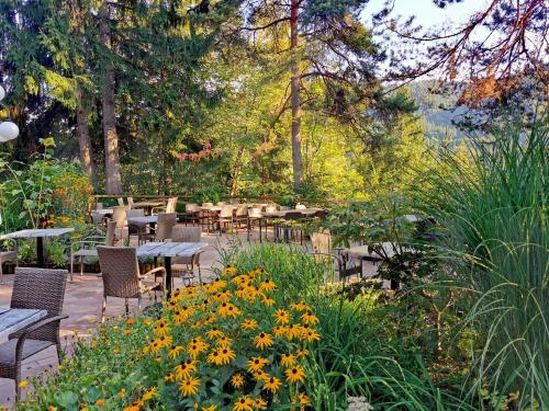 a garden with tables and chairs and flowers at Ribno Alpine Hotel in Bled