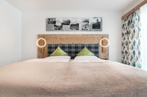 a bedroom with a large bed with green pillows at Gasthof Pension Berghof in Hippach