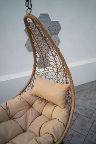 a wicker chair with a pillow in a room at Villa La Pagaia Sorrento Coast in Vico Equense