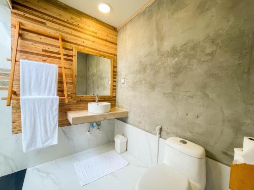 a bathroom with a toilet and a sink at Suffix Retreat in Fuvahmulah