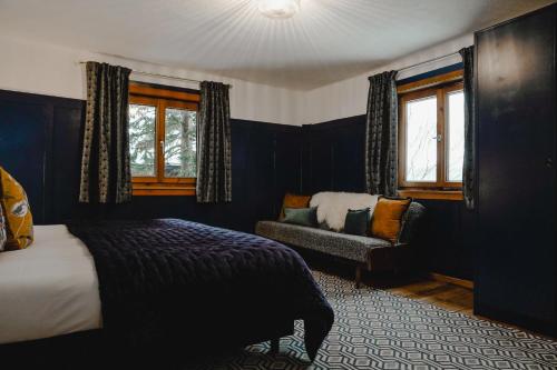 sypialnia z łóżkiem, krzesłem i oknami w obiekcie St Anton 365 w mieście Sankt Anton am Arlberg