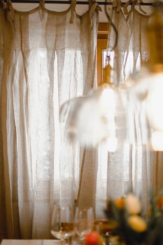 a window with white curtains and a table with glasses at St Anton 365 in Sankt Anton am Arlberg