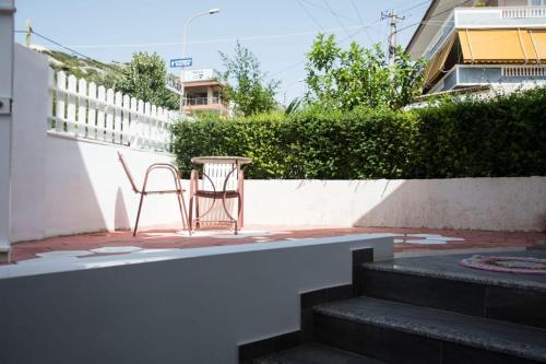 einen Stuhl und einen Tisch auf einer Terrasse mit einem Zaun in der Unterkunft Apartament Stefani in Sarandë