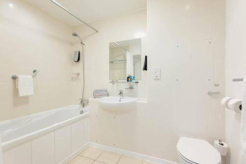 a white bathroom with a sink and a toilet at PREMIER SUITES Newcastle in Newcastle upon Tyne