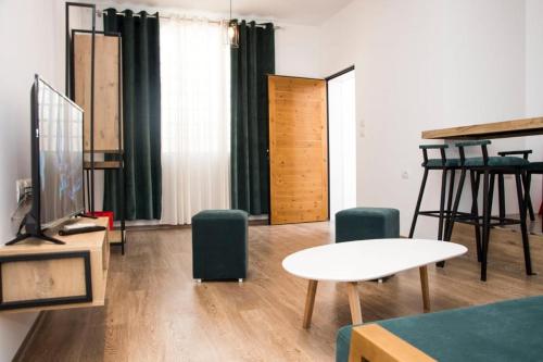 ein Wohnzimmer mit einem Tisch und grünen Stühlen in der Unterkunft Apartament Stefani in Sarandë
