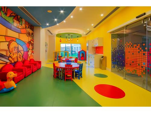 a play room with a red couch and a table at Limak Cyprus Deluxe Hotel in Iskele
