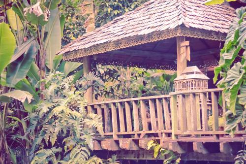 a wooden gazebo in the middle of a garden at Fig Tree Hills Resort (花果山度假村) in Bayan Lepas