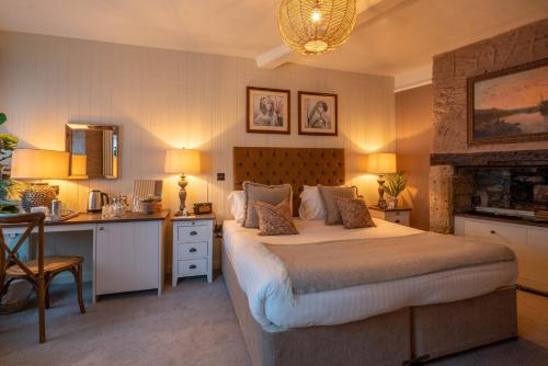 a bedroom with a bed and a desk and a kitchen at The George Inn & Plaine in Norton Saint Philip