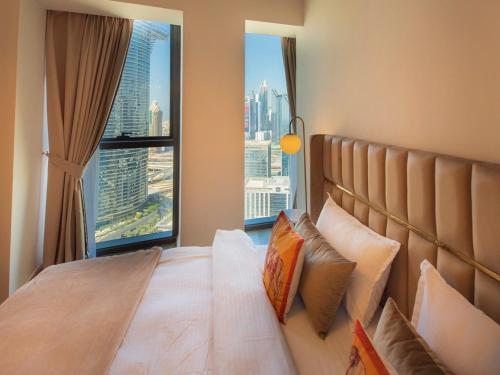 een slaapkamer met een bed en een groot raam bij FIRST CLASS 3BR with full DUBAI SKYLINE & SEA view in Dubai