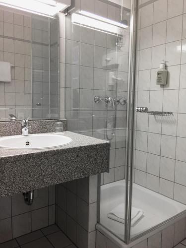 une salle de bain avec un lavabo et une douche dans l'établissement Hotel Schweizer Hof, à Cassel