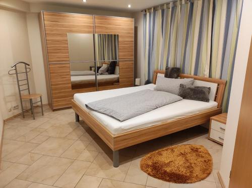 a bedroom with a large bed and a mirror at Ferienwohnung Bleifuss in Altenbuch