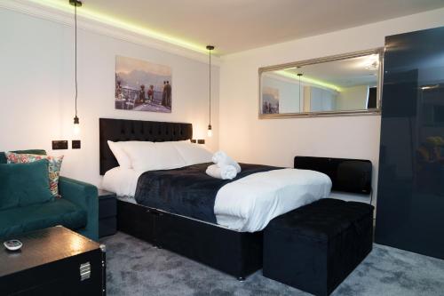 a bedroom with a large bed and a green couch at Willow Studio in Leeds