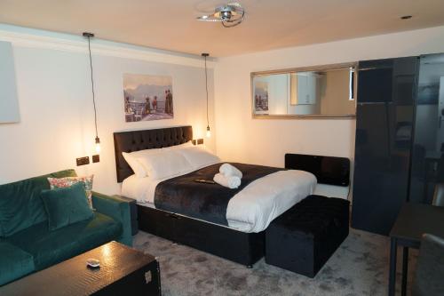 sypialnia z łóżkiem i zieloną kanapą w obiekcie Willow Studio w mieście Leeds