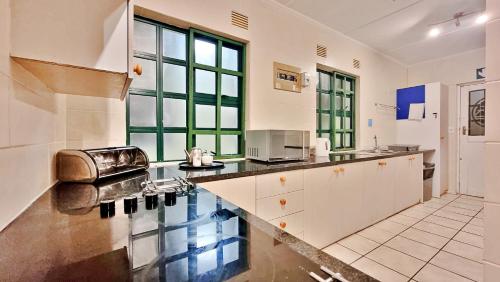 Una cocina grande con gabinetes blancos y encimera. en Settler Sands - Holsboer Vacations, en Port Alfred