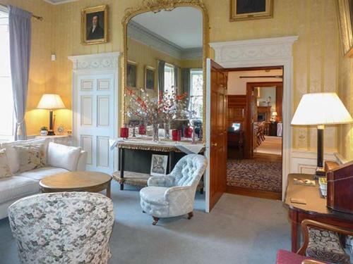 a living room with a couch and chairs and a mirror at Dalvey House in Forres