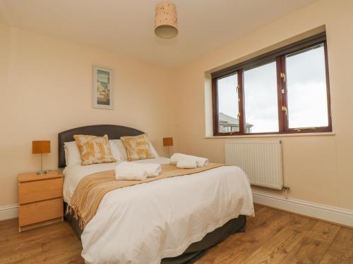 a bedroom with a bed with two towels on it at Sea Horses in Marazion