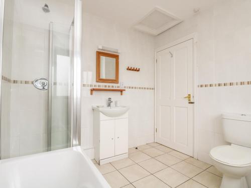 a bathroom with a shower toilet and a sink at Sea Horses in Marazion