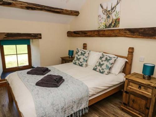 a bedroom with a bed with two towels on it at Cornel Clyd in Llanddulas