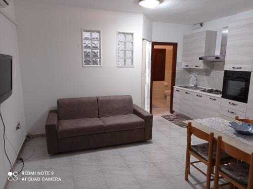 Una sala de estar con un sofá y una cocina. en Tortolì-Porto Frailis-Arbatax, en Àrbatax