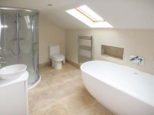 a bathroom with a tub and a sink and a toilet at Ox Hey Barn in Bolton by Bowland