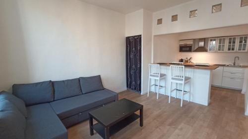 a living room with a blue couch and a kitchen at Studio Neuf Climatisé Centre Ville #7 in Toulon