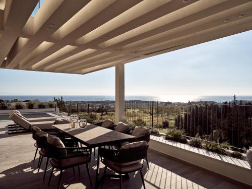 a dining room with a table and chairs on a balcony at Alexandra SeaView Luxurious Villa, By ThinkVilla in Vasilikos