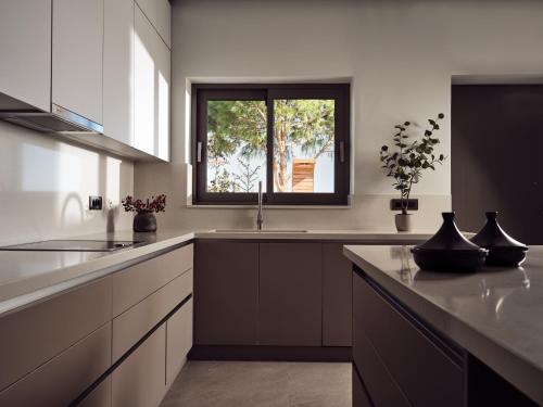 a kitchen with a sink and a window at Alexandra SeaView Luxurious Villa, By ThinkVilla in Vasilikos