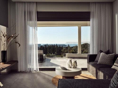 a living room with a couch and a large window at Alexandra SeaView Luxurious Villa, By ThinkVilla in Vasilikos