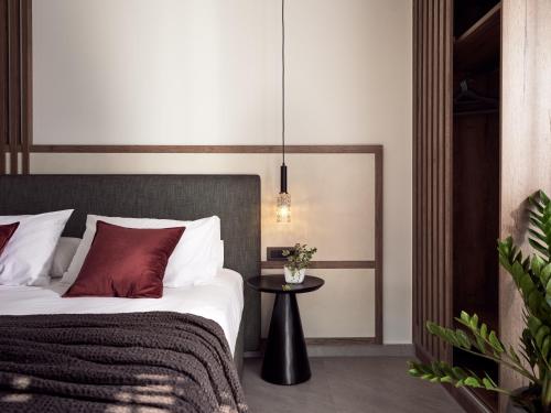 a bedroom with a bed with red pillows and a table at Alexandra SeaView Luxurious Villa, By ThinkVilla in Vasilikos