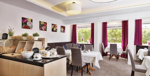 a dining room with tables and chairs and windows at Hotel Stern in Ehrwald