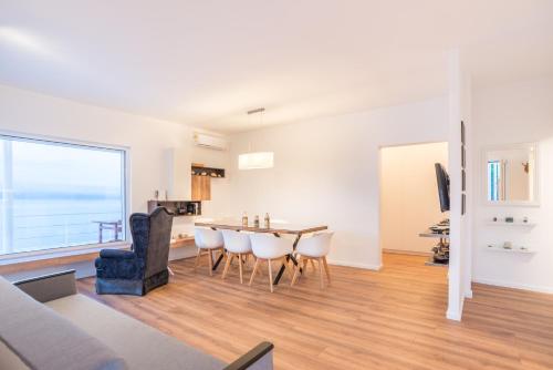 a dining room and living room with a table and chairs at Epipleon suites in Áyioi Apóstoloi
