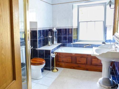 La salle de bains est pourvue d'une baignoire, de toilettes et d'un lavabo. dans l'établissement Gavel Cottage, à Bowness-on-Windermere