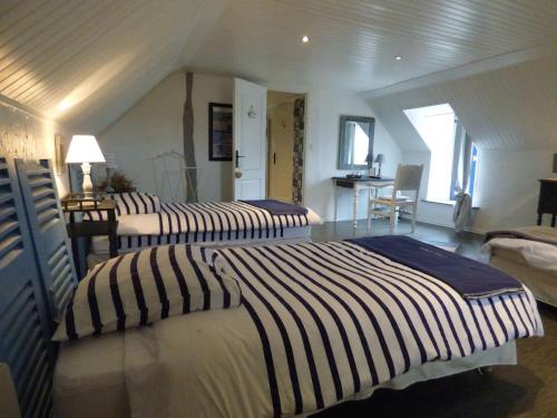 een slaapkamer met 2 bedden met gestreepte lakens bij La Glycinière Chambres d'Hôtes in Pont-Croix