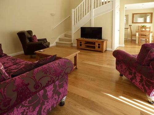 a living room with two couches and a television at Setch Barn in Masham