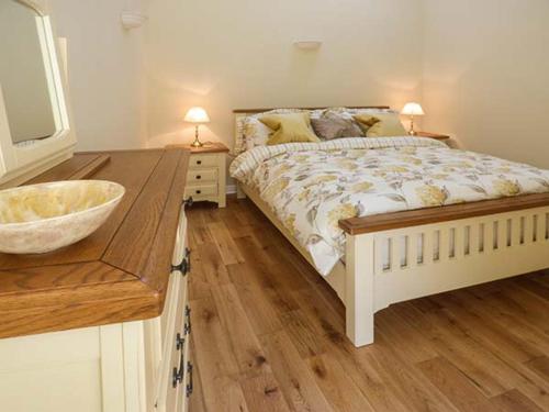 um quarto com uma cama e um lavatório em Setch Barn em Masham