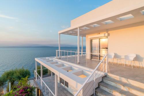 a house with a view of the water at Epipleon suites in Áyioi Apóstoloi