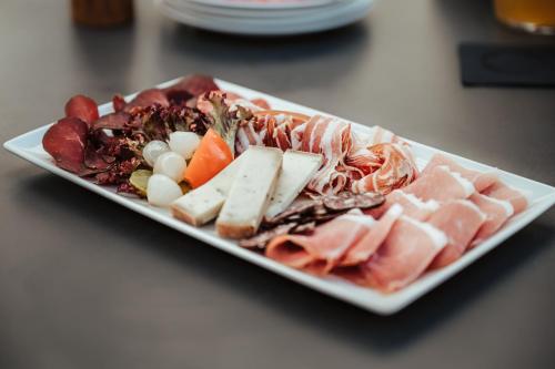 a plate of food with meat and vegetables on a table at Hotel Sporting in Marbach