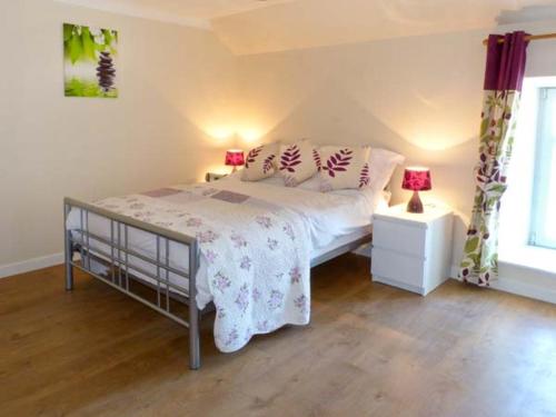 a bedroom with a bed with pillows on it at Sky Blue Cottage in Forth