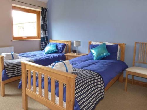 a bedroom with two beds and a window at Pottowe Cottage in Potto