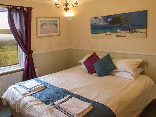 302 Over Lane Cottage في بيلبير: غرفة نوم عليها سرير وفوط