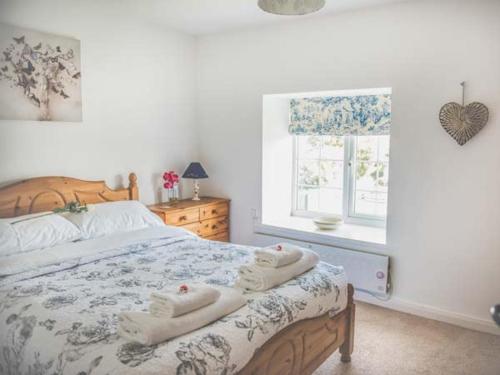 ein Schlafzimmer mit einem Bett mit Handtüchern darauf in der Unterkunft Tyddyn Gyrfa Cottage in Cemaes Bay