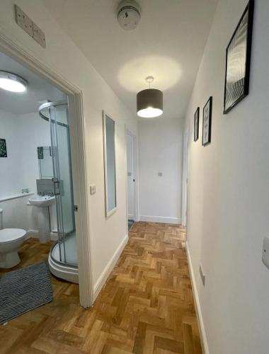 uma casa de banho com uma cabina de duche em vidro e um WC. em Prosper House Apartment 5 em Norwich
