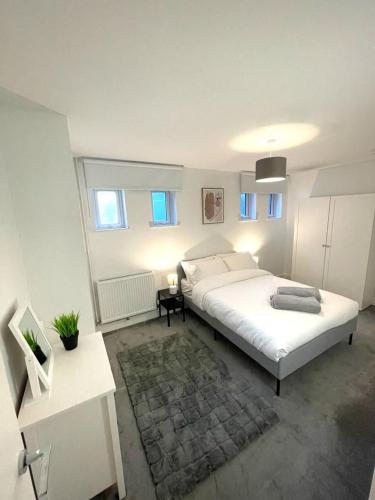 um quarto com uma grande cama branca num quarto em Prosper House Apartment 5 em Norwich