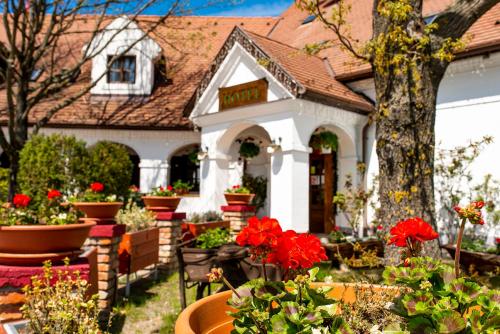 a house with flowers in front of it at Gastland M1 Hotel & Conference Center in Páty